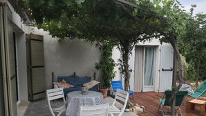 An outdoor patio with a table and chairs, a covered seating area, and a wooden deck. - Pretty house Aix en provence / Fuveau (Fuveau)