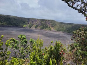 A volcanic landscape with a lava field and forested hills in the background. - Air Conditioned 2 Bedrooms 1 Bath Apartment, fine decorated, Free Laundry in HPP (Keaau)