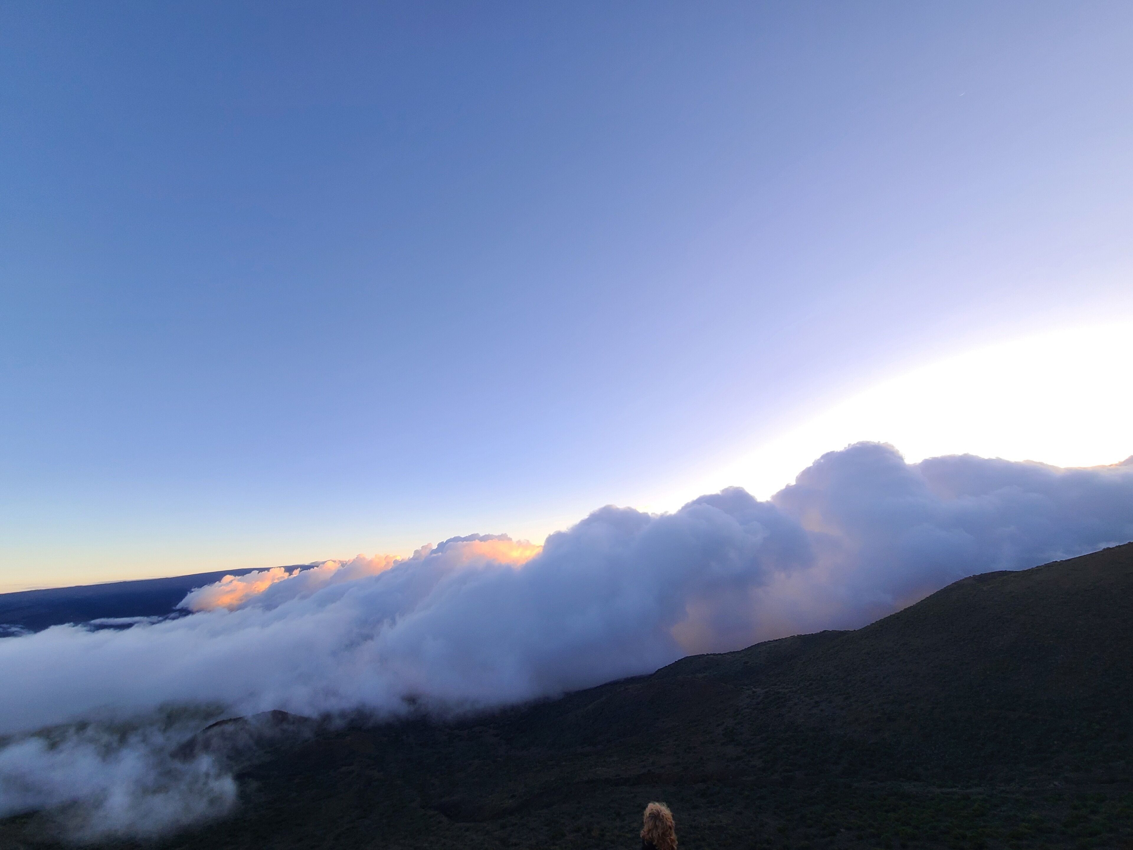 A mountainous landscape with a clear sky and clouds.