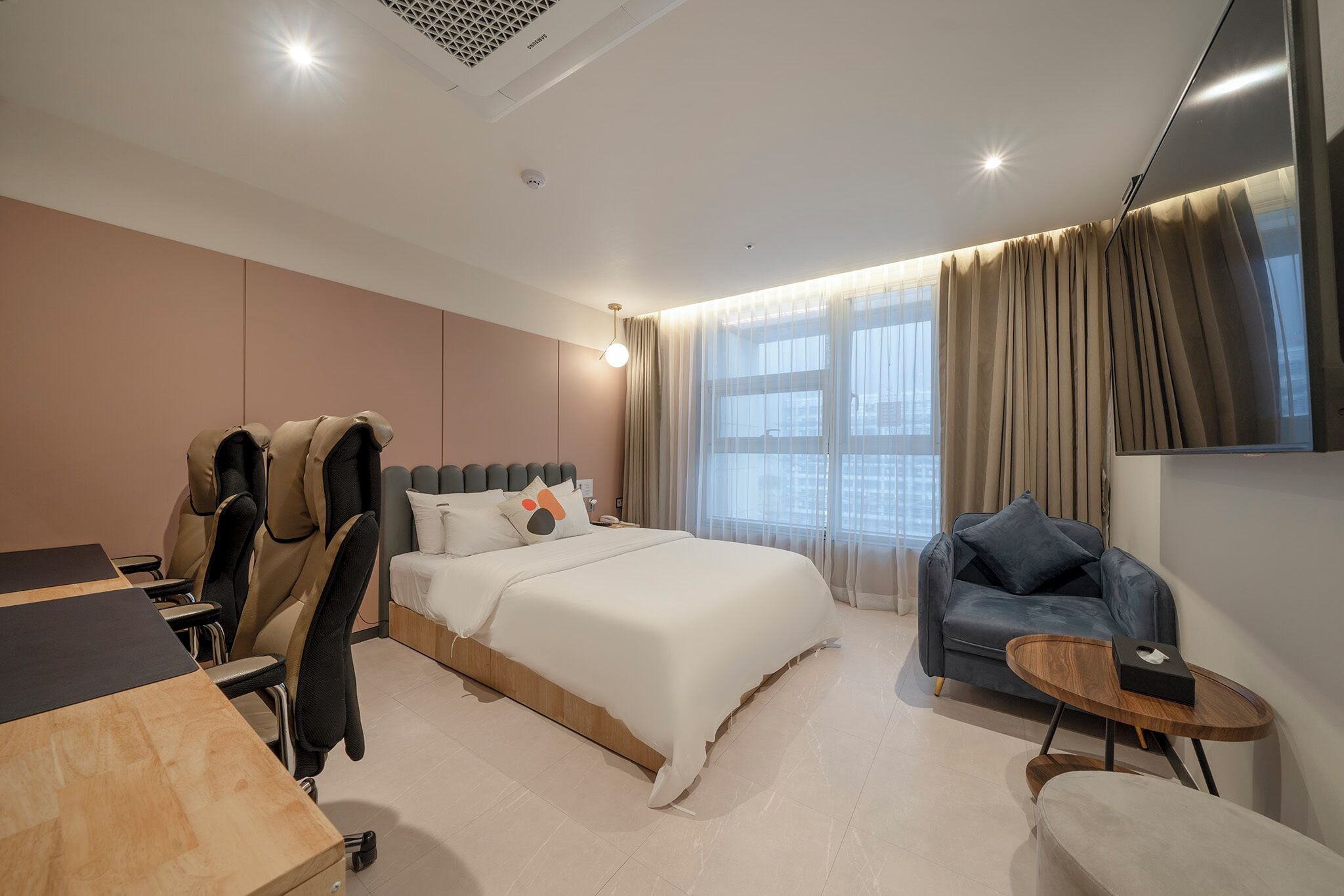 Une chambre d’hôtel moderne équipée d’un lit, d’un coin salon et d’un bureau.
