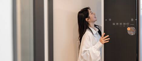 A person standing in front of a door with a digital interface.