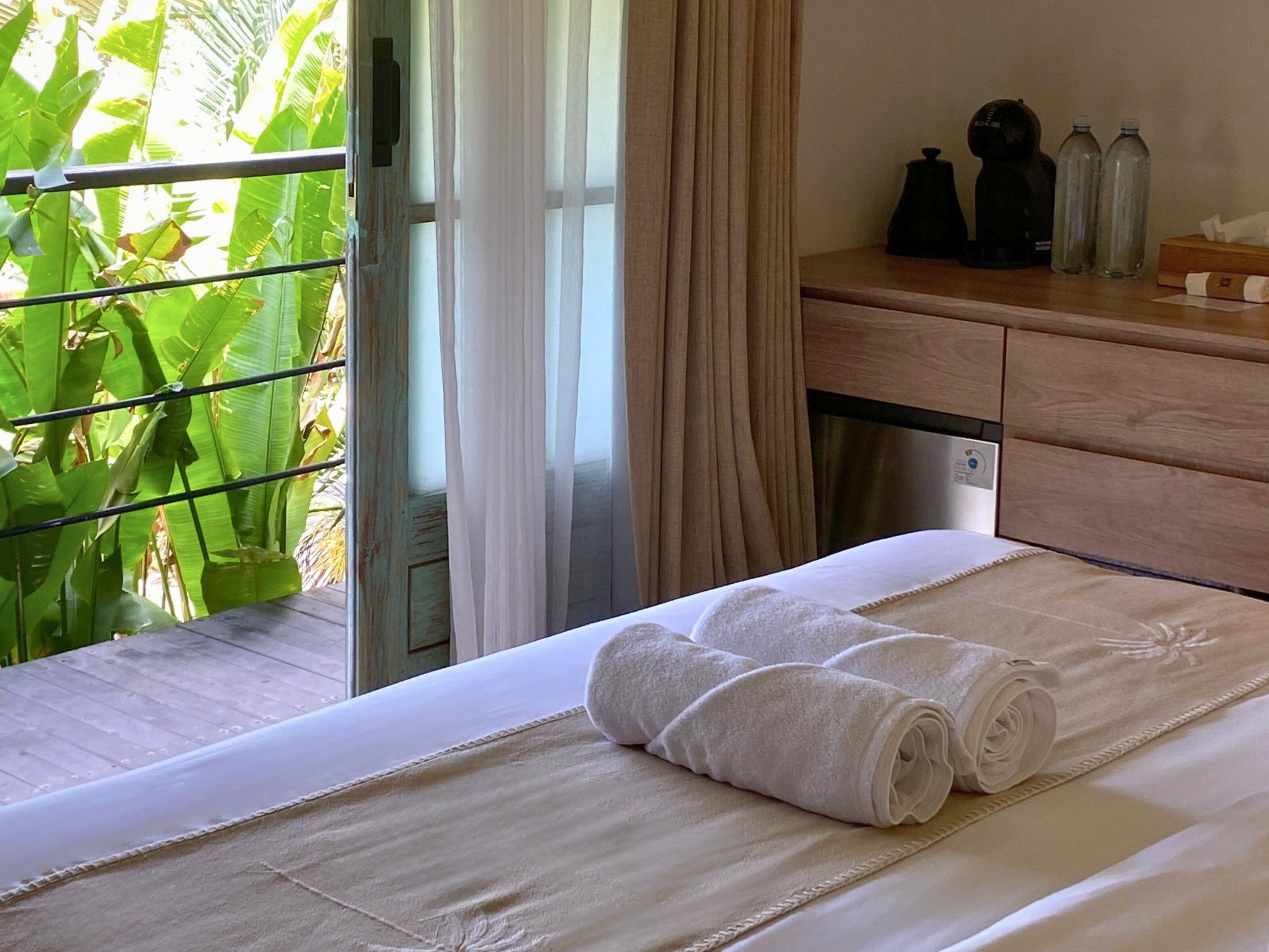 Una habitación de hotel con una cama, un aparador de madera y una ventana con cortinas.
