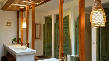 Un baño moderno con vigas de madera, dos lavamanos y una lámpara colgante.