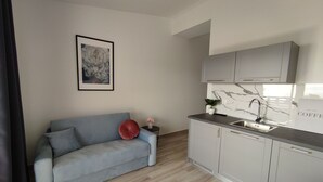 A modern kitchen with grey cabinets, a marble backsplash, and a built-in sink. - Bloom Apartments & Lounge Bar (Vir)