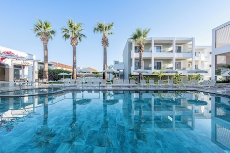 Una piscina al aire libre, sillones reclinables de piscina