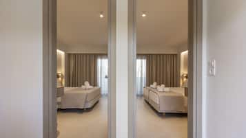 Reflejo de una habitación de hotel con dos camas, un ventanal con cortinas y una puerta con pomo.