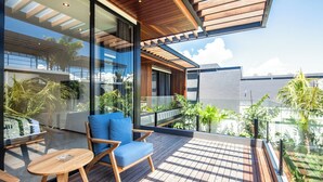 Un balcon moderne avec un plancher en bois, une chaise bleue et une petite table.