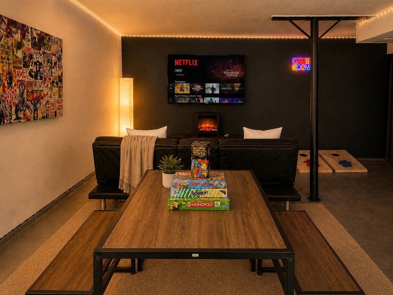 A living room with a wooden coffee table, black sofa, and a TV mounted on the wall displaying Netflix.