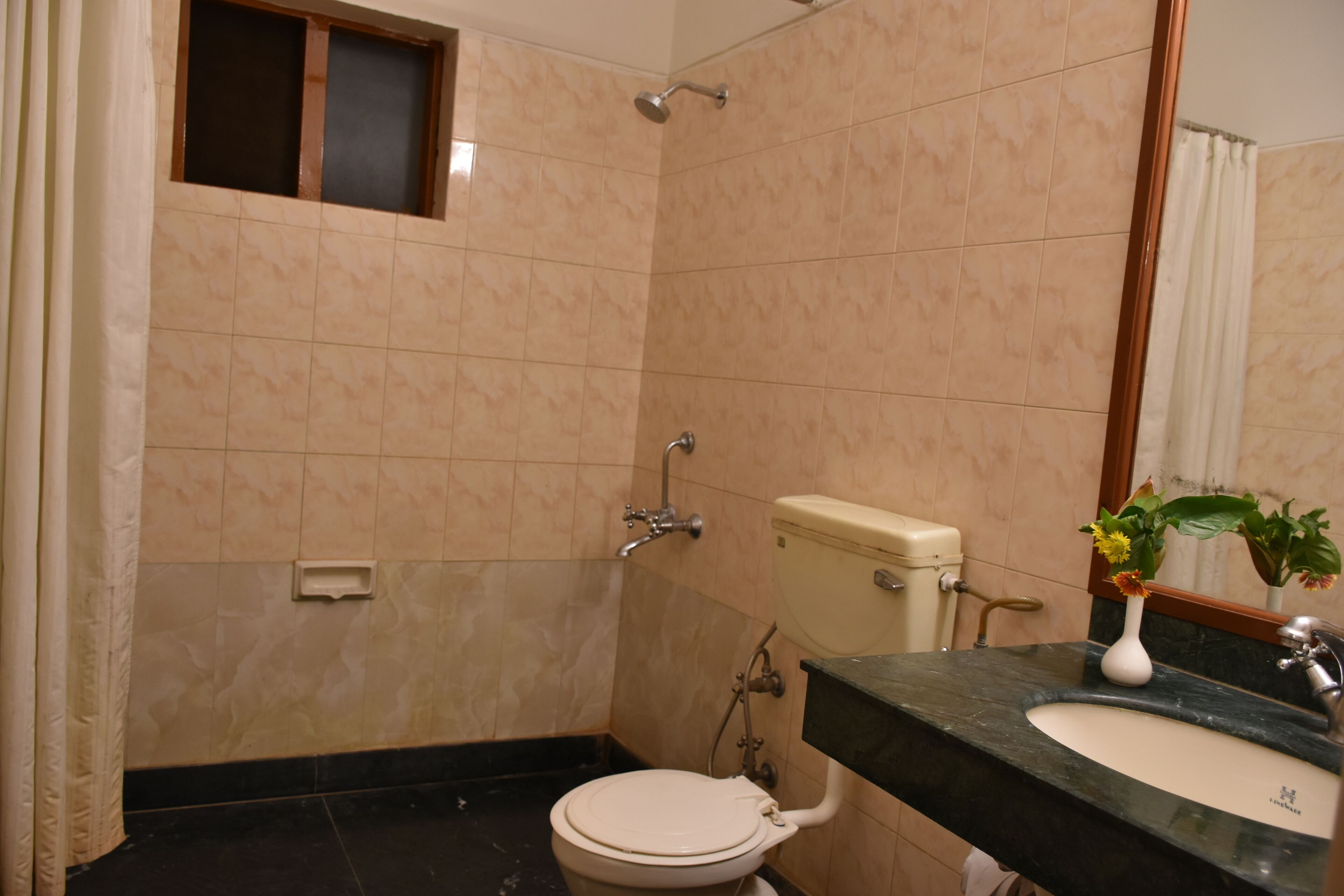 Une salle de bain équipée de toilettes, d’un lavabo et d’une douche.