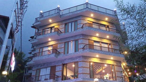 Un edificio de varios pisos con balcones, ventanas amplias y zonas de estar al aire libre.
