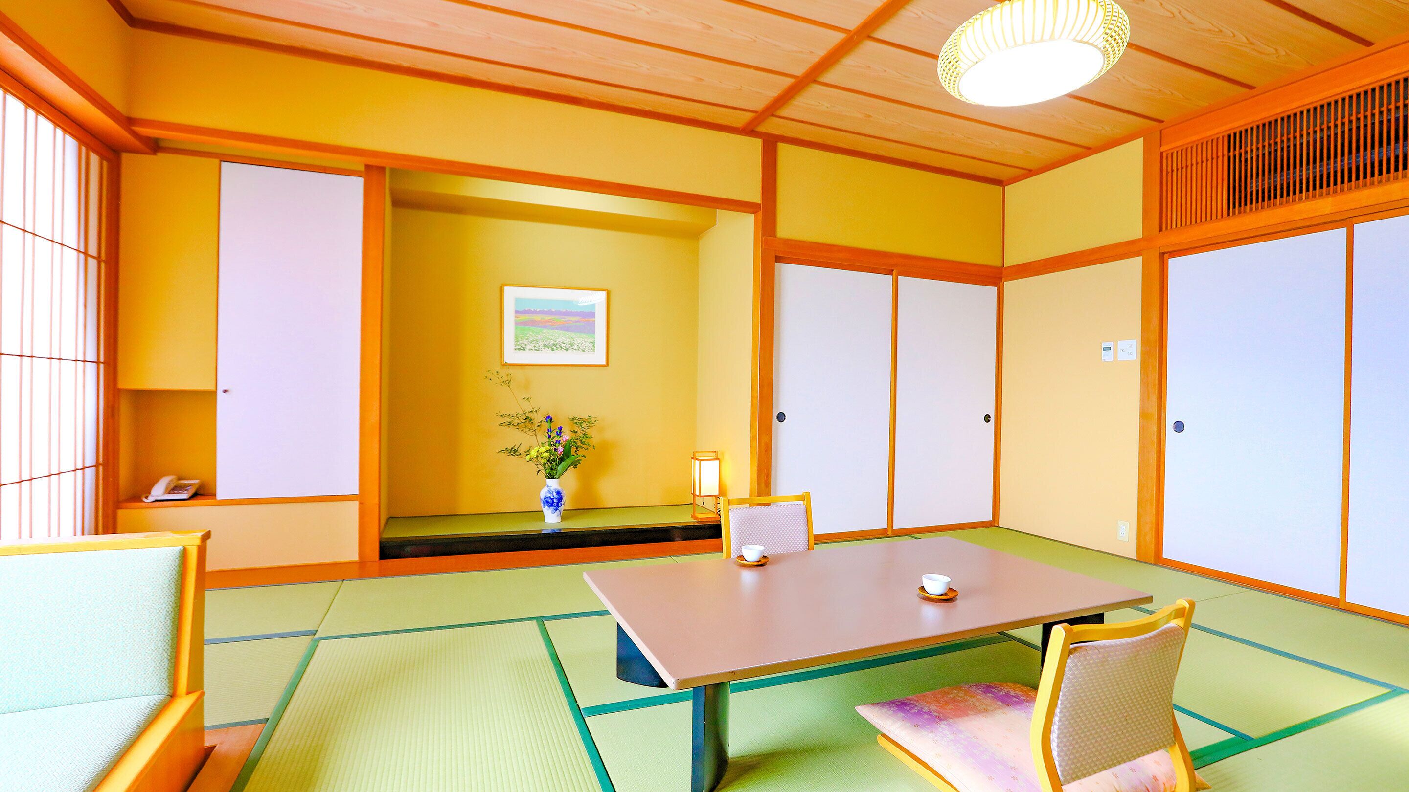 A traditional Japanese room with tatami flooring, a low table, and shoji screens.