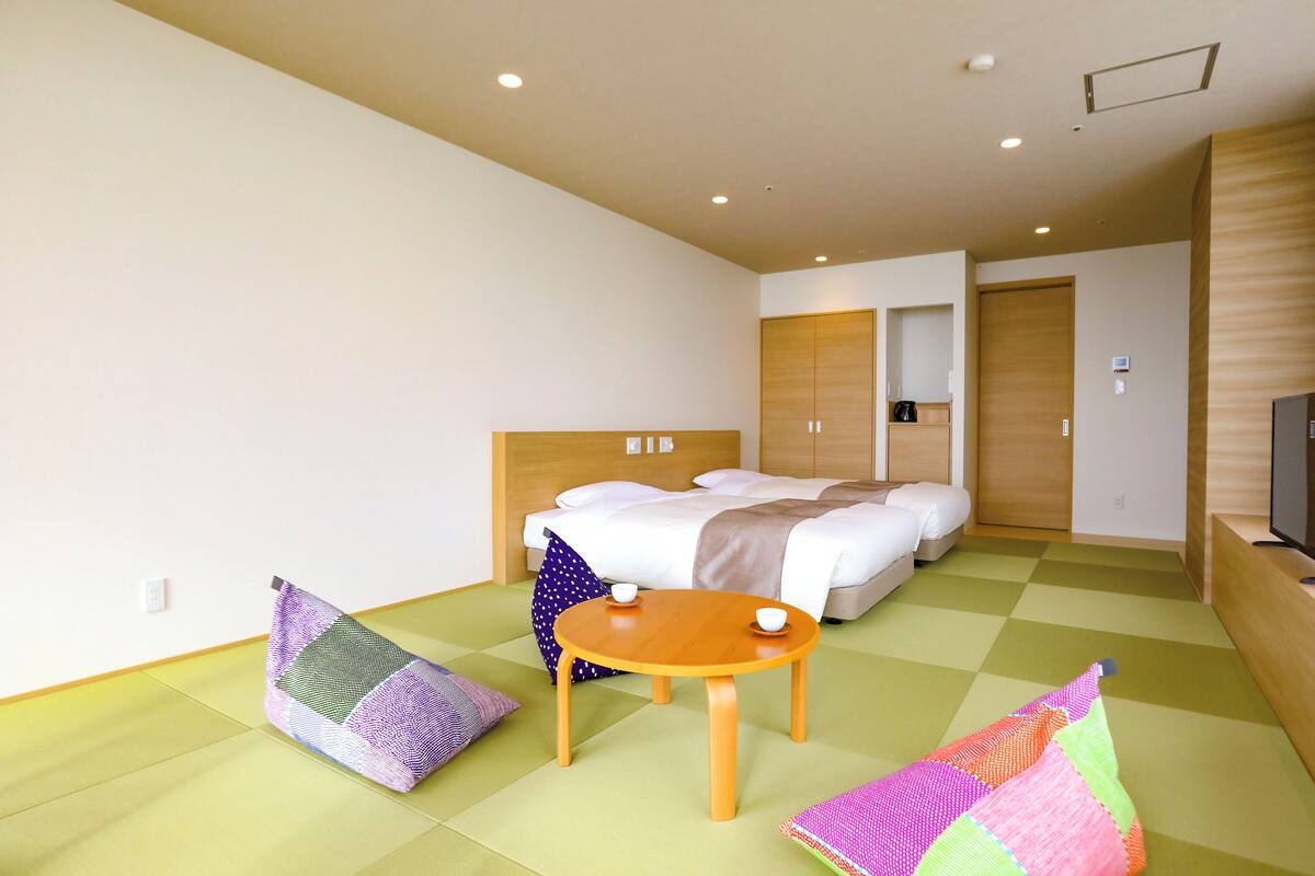 Una habitación de hotel con una cama, una mesita y una televisión.