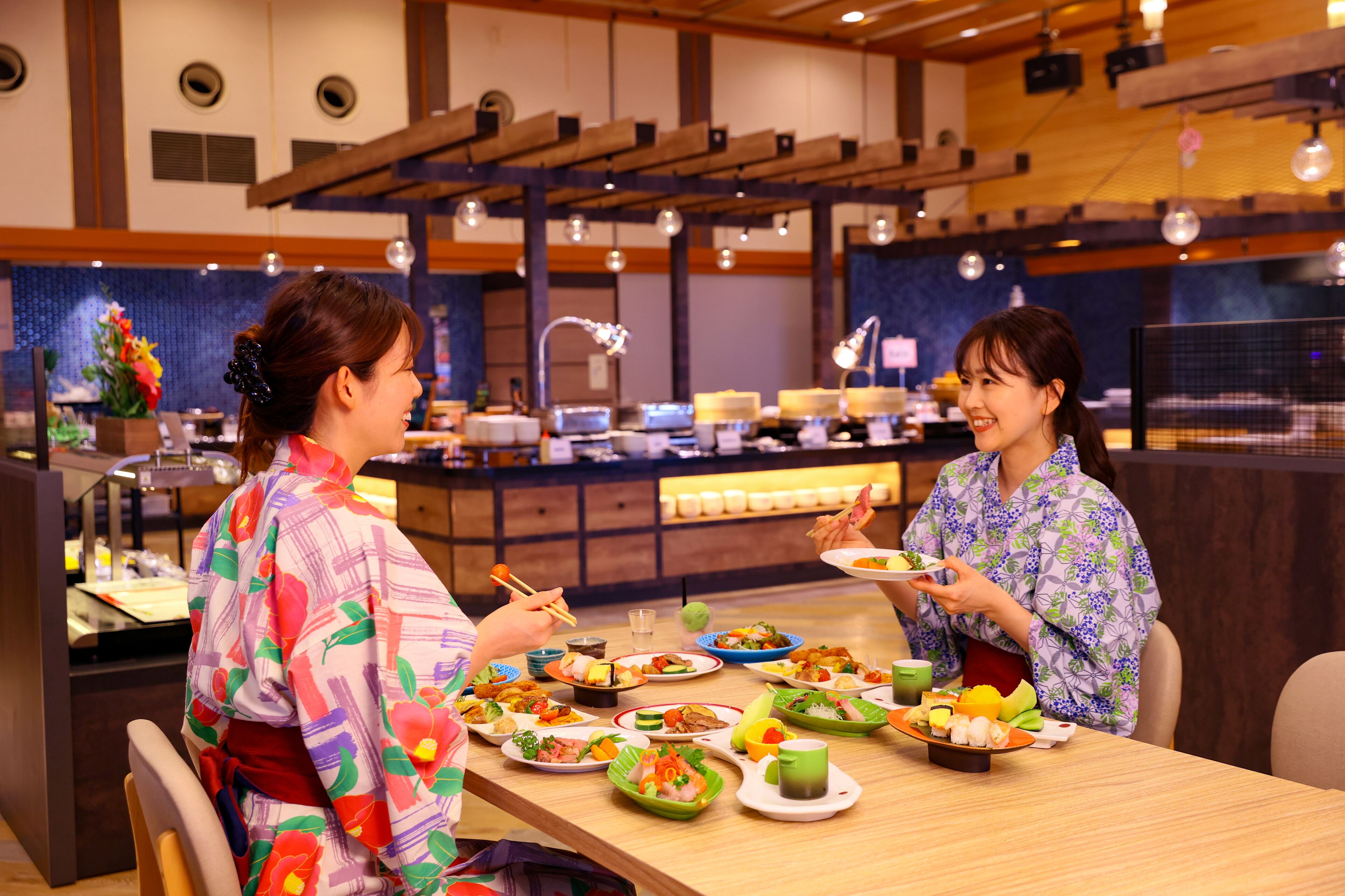 A restaurant with a wooden interior, a counter with various dishes, and two people dining.