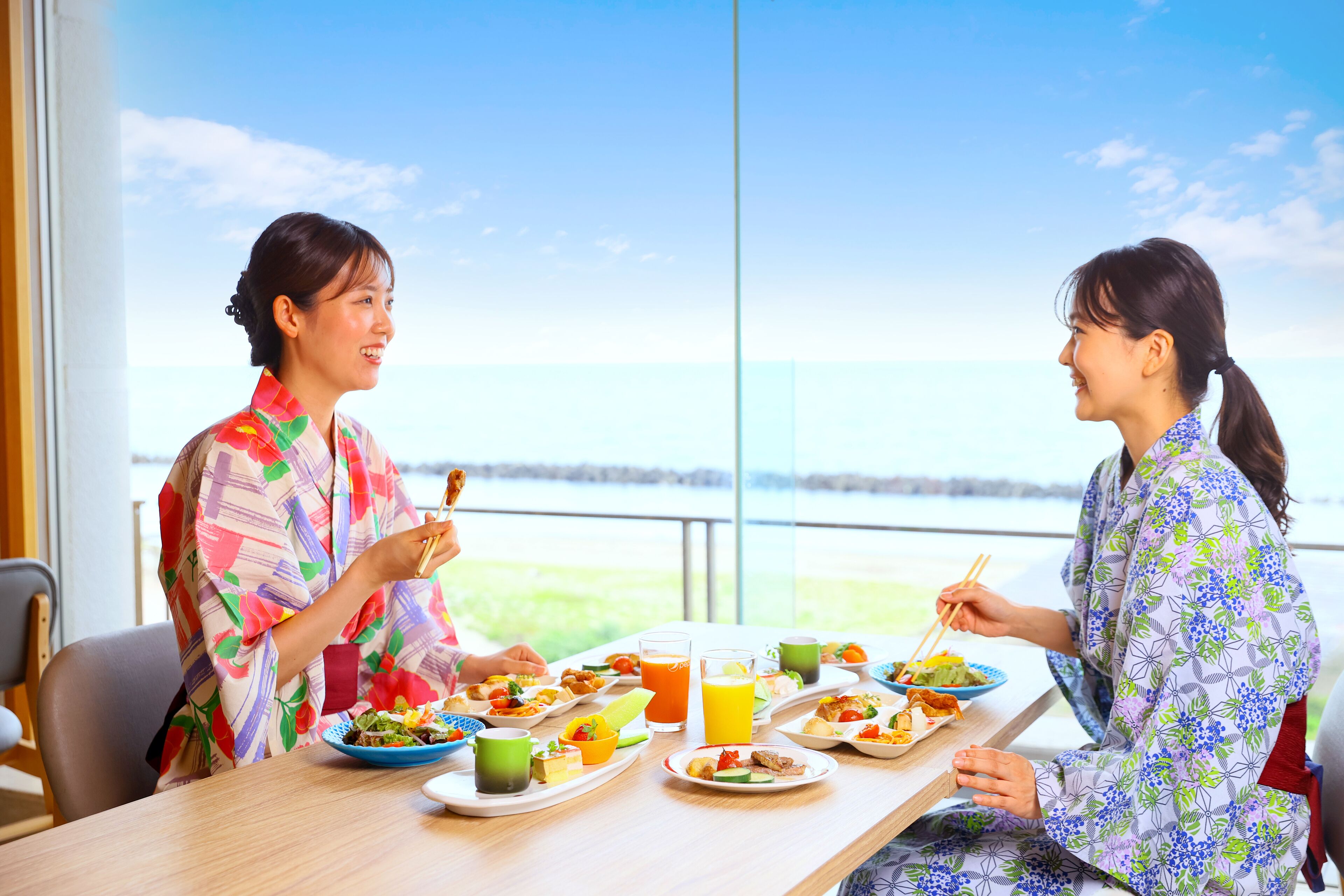 Twee personen dineren aan een tafel met uitzicht op het omliggende landschap.