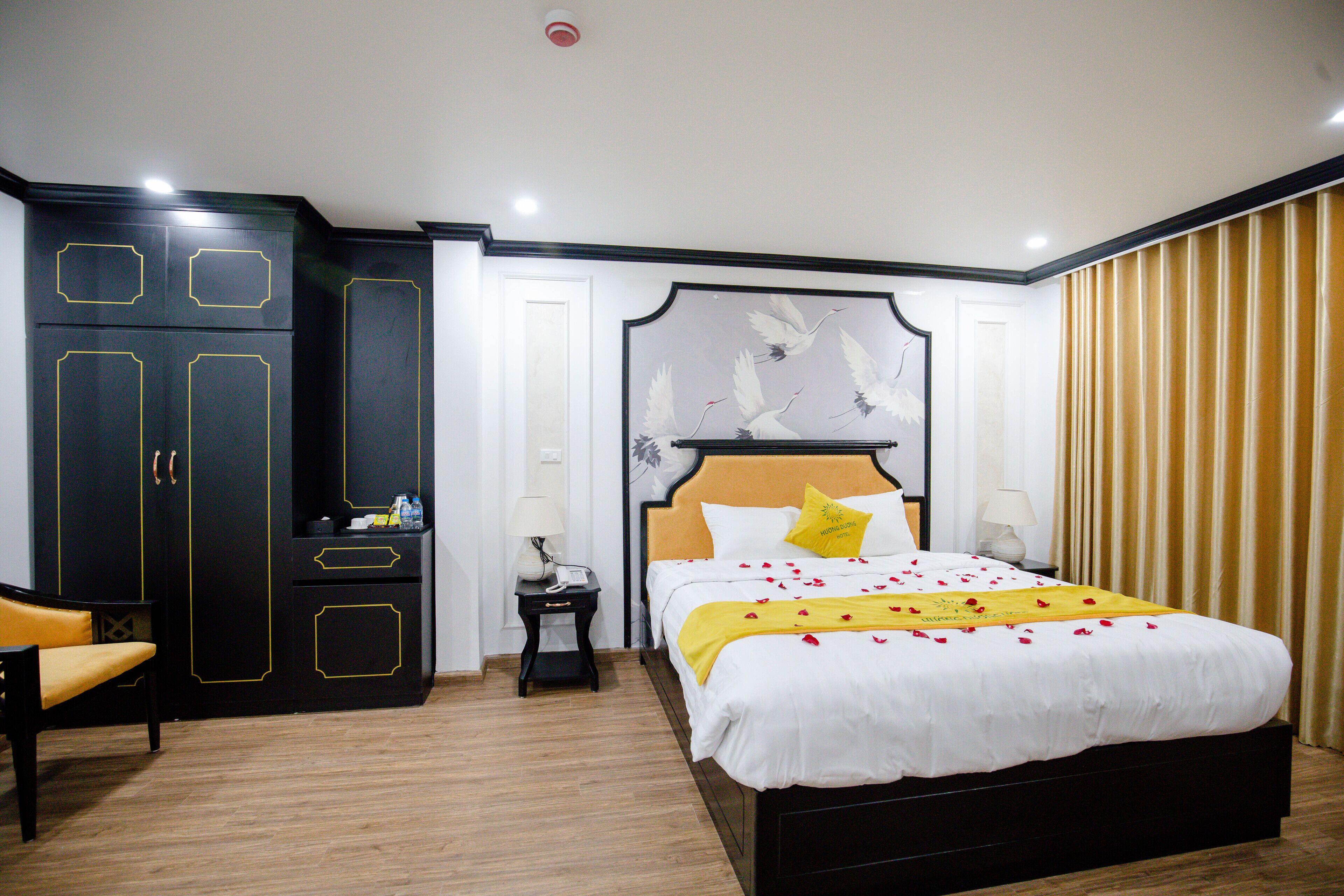Une chambre d’hôtel avec un grand lit, une armoire, une table de chevet et une chaise.