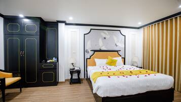 Een hotelkamer met een groot bed, een kast, een nachtkastje en een stoel.