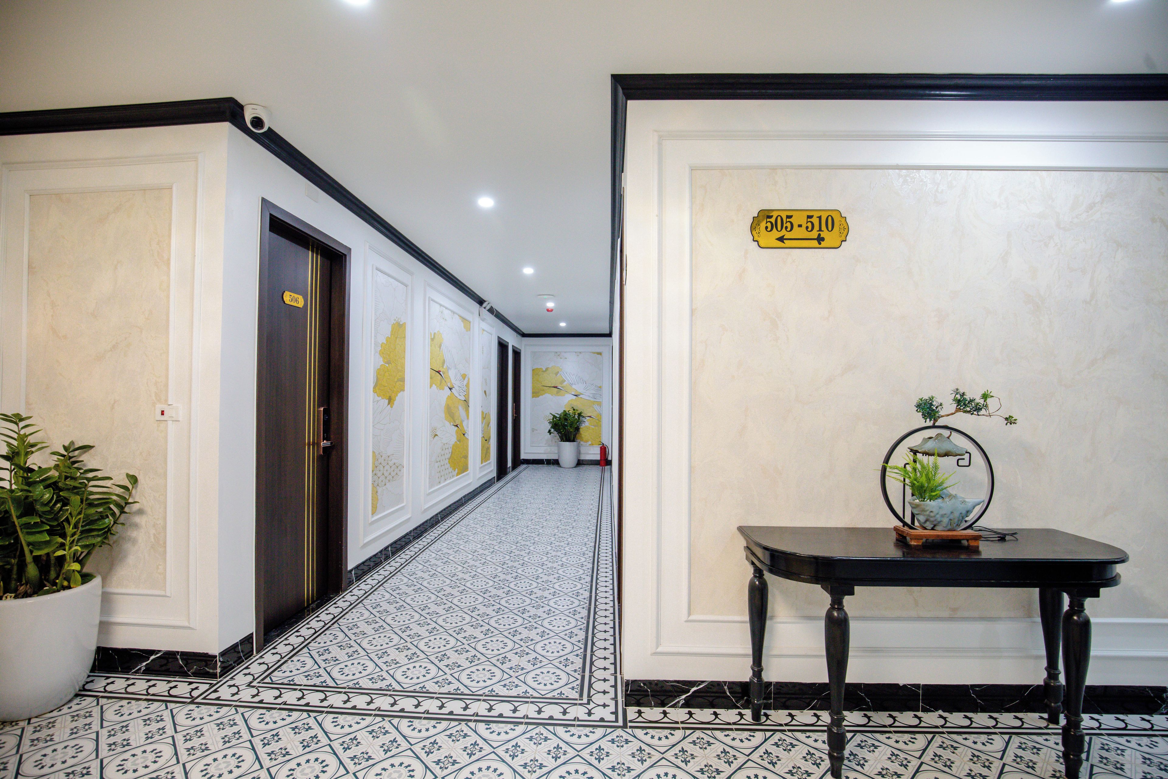 A hotel corridor with doors numbered 506 and 510, a potted plant, and a table with a decorative item.