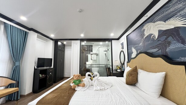 A hotel room with a bed, a television, a wardrobe, a desk, and a bathroom visible through an open door. - Huong Duong Hotel Thanh Hoa (Hac Thanh)