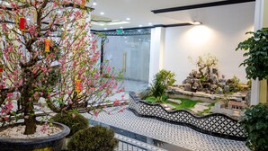 A traditional Japanese garden with a koi pond, a bonsai tree, and a small rock garden. - Huong Duong Hotel Thanh Hoa (Hac Thanh)