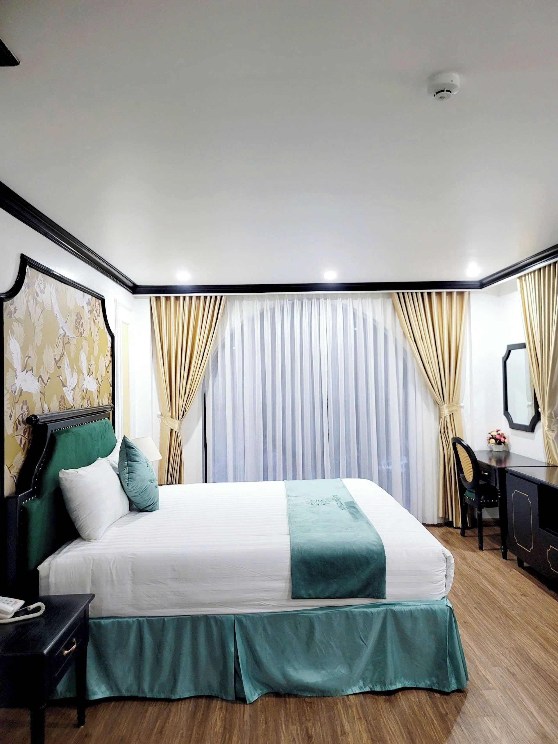 Een hotelkamer met een bed, bureau, stoel en spiegel.