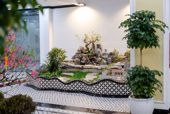 Un paisaje modelo con rocas, un árbol y un pequeño edificio.