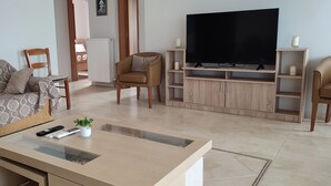 A living room with a sofa, chairs, a TV, and a coffee table.