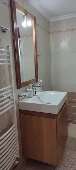 A bathroom with a white sink, wooden vanity, and a mirror with lights. - ALONI cottage (Chania)
