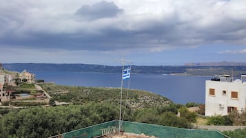 A coastal view with buildings, a flag, and a clear sky.