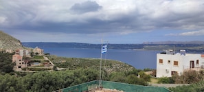 A coastal view with buildings, a flag, and a clear sky. - ALONI cottage (Chania)