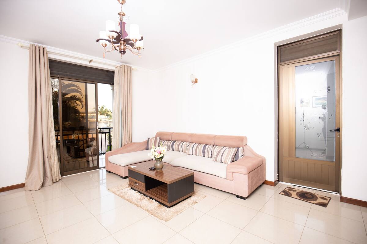 A living room with a sofa, coffee table, and a chandelier.
