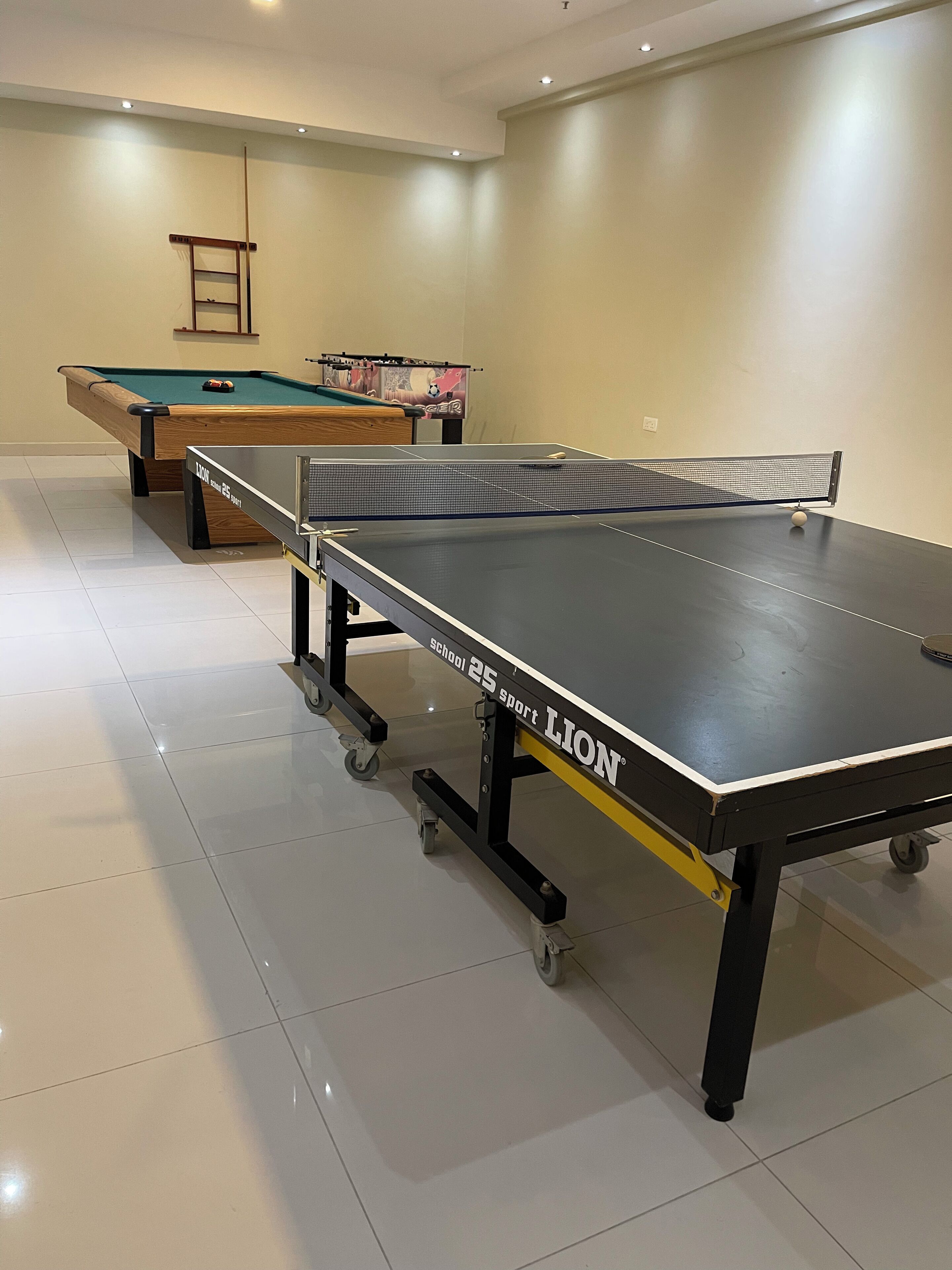 A billiards room with a pool table, a snooker table, and a table tennis table.