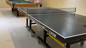 A billiards room with a pool table, a snooker table, and a table tennis table.