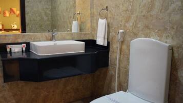 A modern bathroom with a white sink, black countertop, and a white toilet.