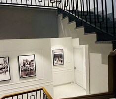 A staircase with a handrail and a door at the bottom.
