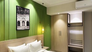 A hotel room with a bed, a wardrobe, a ceiling fan, and a wall-mounted air conditioner. - Hotel Wonder Hills @ Har ki Pauri Road Haridwar (Haridwar)