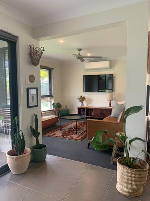 Relax in this cozy living space with a comfortable seating area, flat-screen TV, and ceiling fan.