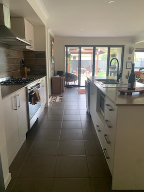 Enjoy cooking in this well-equipped kitchen with a central island, stove, oven, and sink, and step out to a patio with dining area.