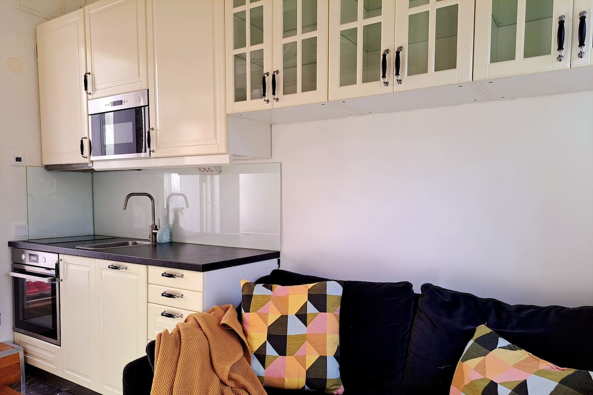 A compact kitchen with white cabinets, a microwave, and a sink.