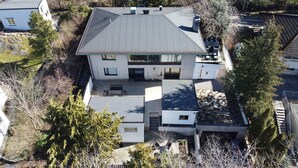 A two-story house with a sloped roof, a covered patio, and a stone pathway leading to the entrance. - TG Oasis Örgryte Stugor & Rum (Gothenburg)