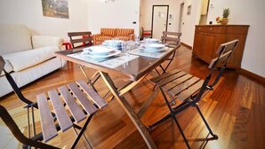A dining area with a wooden table set for four, surrounded by chairs with metal frames. - HOUSE OF PRINCE AMBA ALAGI (ST. MARITIME) GENOVABNB.IT (GENOVA)