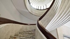 A spiral staircase with marble steps and a wooden handrail, leading to a circular skylight. - HOUSE OF PRINCE AMBA ALAGI (ST. MARITIME) GENOVABNB.IT (GENOVA)