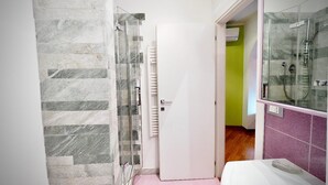 Une salle de bain moderne avec une douche à parois de verre, des toilettes blanches et un sol carrelé rose.