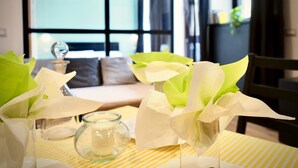 Una mesa con un candelabro de vidrio y un florero con flores blancas.
