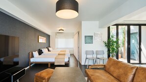 A modern hotel room with a bed, a sofa, a TV, and a dining area. - ALFACIO RIVERSIDE STAY HAKATA (Fukuoka)