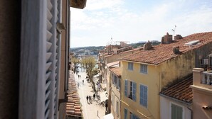 Vista di una strada con edifici, un fiume e persone che passeggiano.