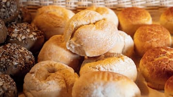Uma cesta com diferentes tipos de pão, incluindo alguns com sementes.