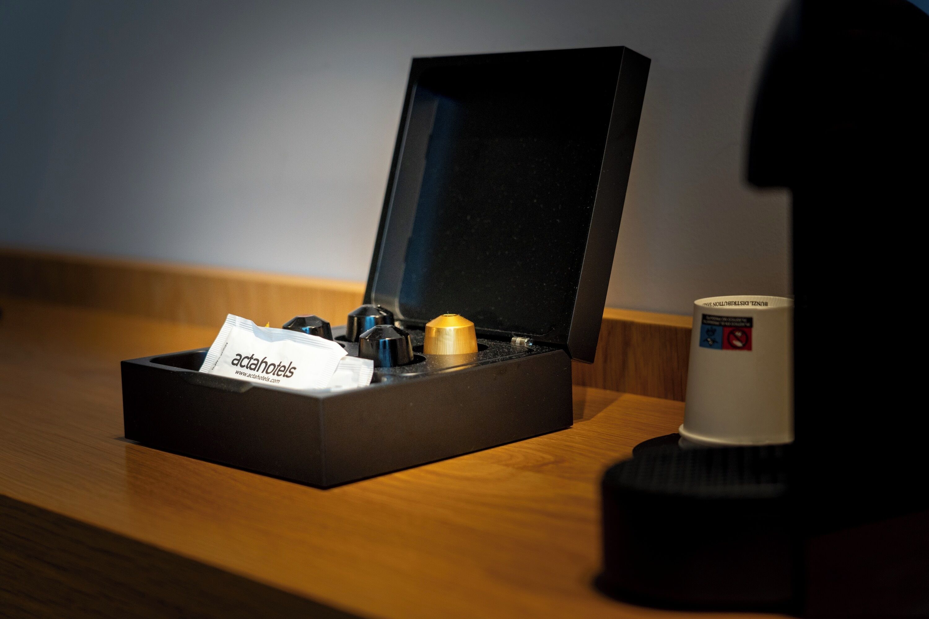A black box with a tissue and a small item on a wooden surface.