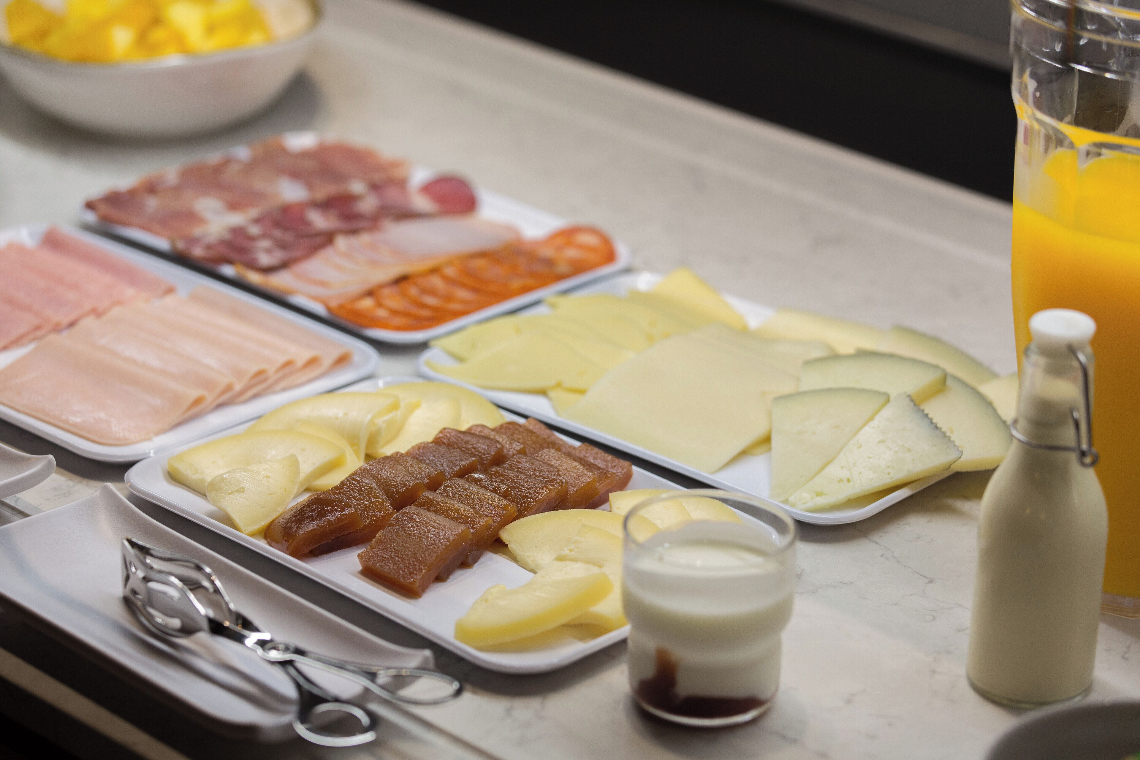 Un buffet de petit-déjeuner proposant une variété de viandes, de fromages et de fruits.