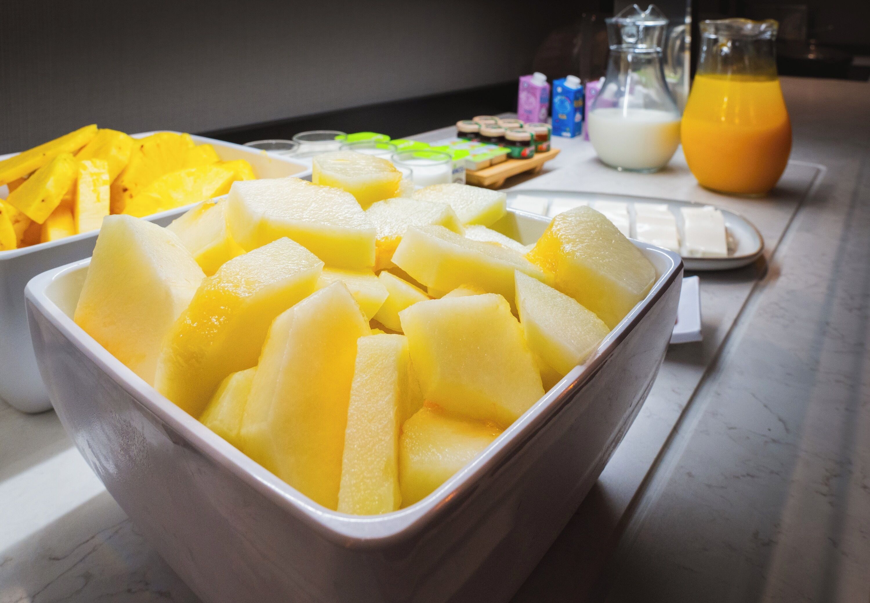 En frukostbuffé med ett urval av olika frukter och drycker.