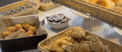 En buffé med ett urval av olika bakverk, inklusive croissanter och småkakor.